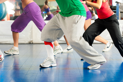 Fitness - Young people (only legs to be seen) doing Zumba training or dance workout in a gym